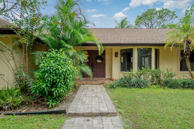 view of exterior entry with a yard