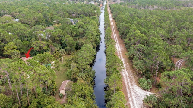 birds eye view of property with a view of trees and a water view