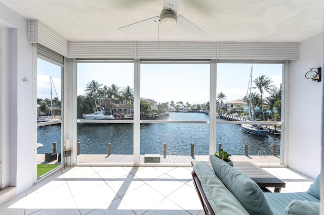 unfurnished sunroom with a water view and ceiling fan