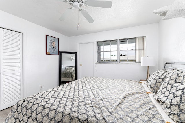 bedroom featuring a textured ceiling, ceiling fan, and a closet