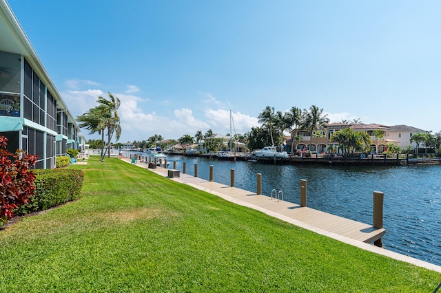 dock area with a lawn and a water view