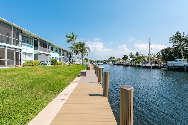 dock area with a lawn and a water view