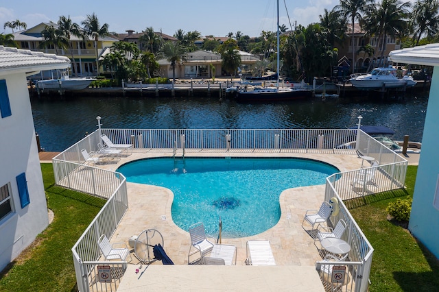 view of swimming pool featuring a patio and a water view