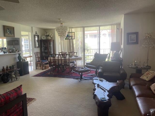 living room with ceiling fan with notable chandelier, a textured ceiling, and carpet flooring