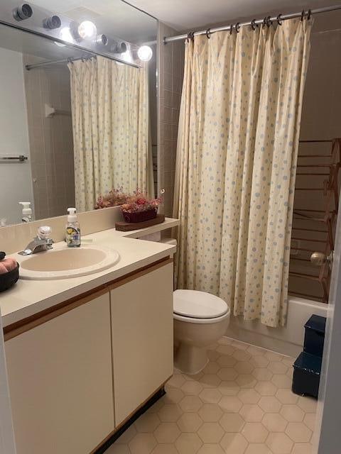 full bathroom featuring tile patterned flooring, vanity, toilet, and shower / bath combination with curtain