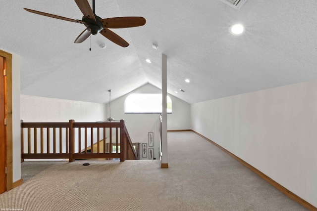 bonus room with a textured ceiling, carpet floors, lofted ceiling, and ceiling fan