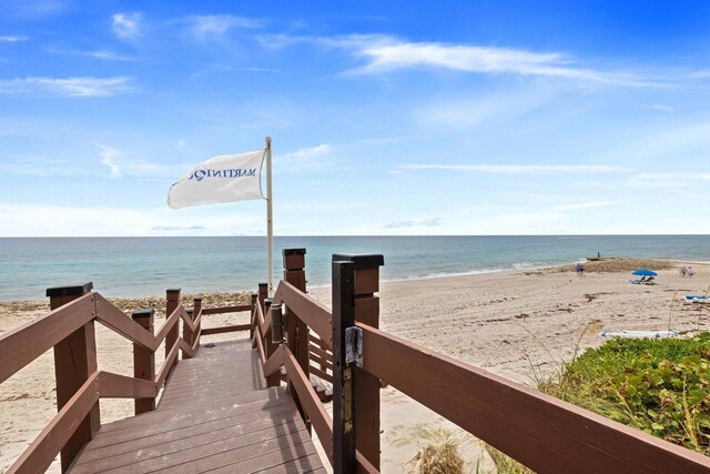 surrounding community featuring a view of the beach and a water view