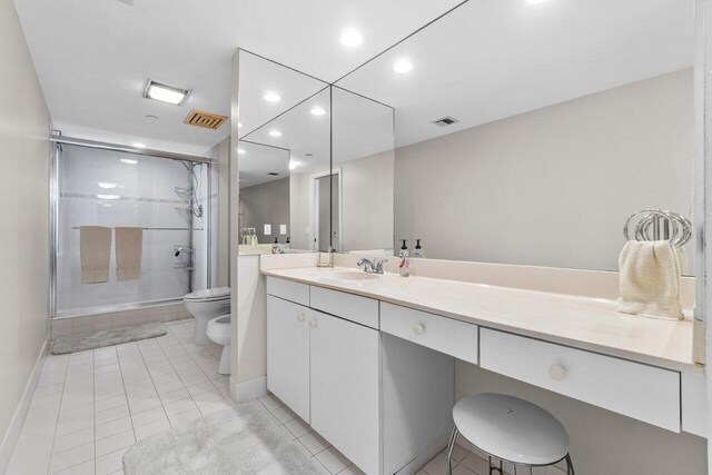 bathroom with a bidet, vanity, walk in shower, tile patterned flooring, and toilet