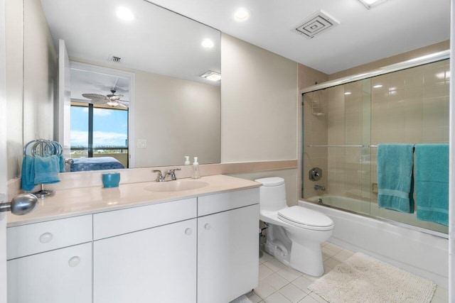 full bathroom featuring toilet, tile patterned floors, vanity, ceiling fan, and bath / shower combo with glass door