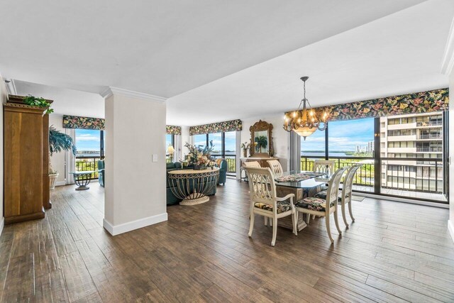 dining room with a chandelier, plenty of natural light, dark hardwood / wood-style flooring, and ornamental molding