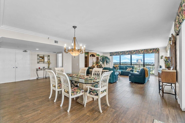 dining room with dark hardwood / wood-style floors, a chandelier, and crown molding