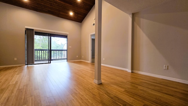 empty room featuring high vaulted ceiling, light wood-type flooring, and wood ceiling