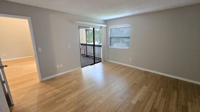 unfurnished room featuring hardwood / wood-style flooring and a textured ceiling