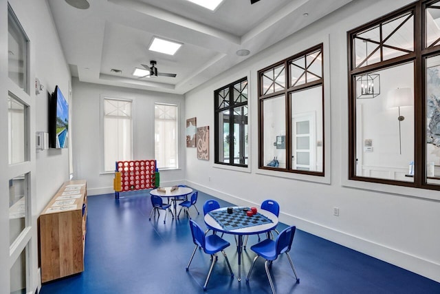 playroom with coffered ceiling and ceiling fan with notable chandelier