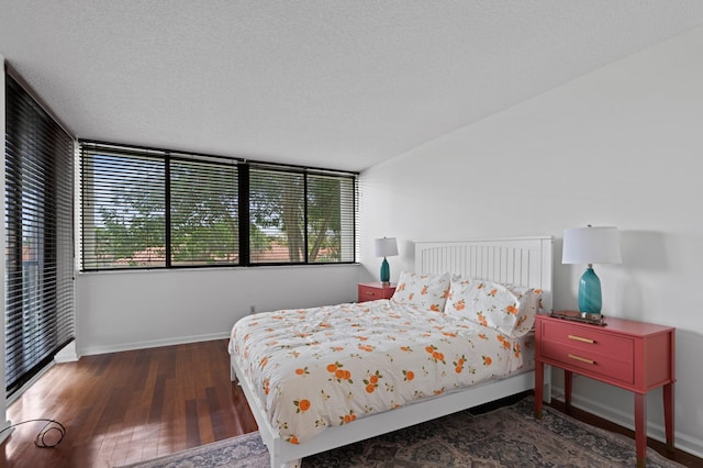 bedroom featuring a textured ceiling and dark hardwood / wood-style floors