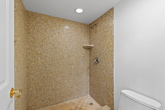 bathroom featuring tiled shower and toilet