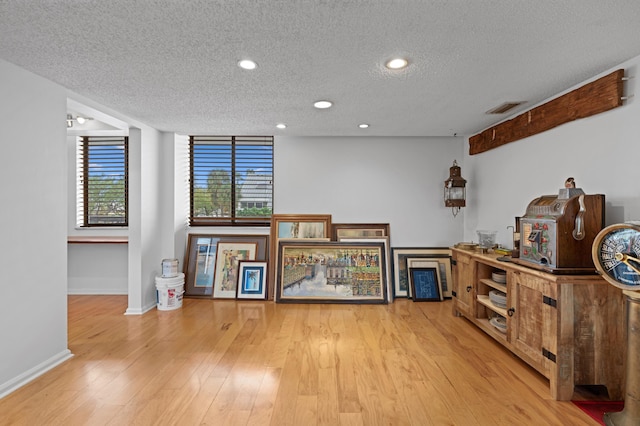 misc room with a textured ceiling and light hardwood / wood-style flooring