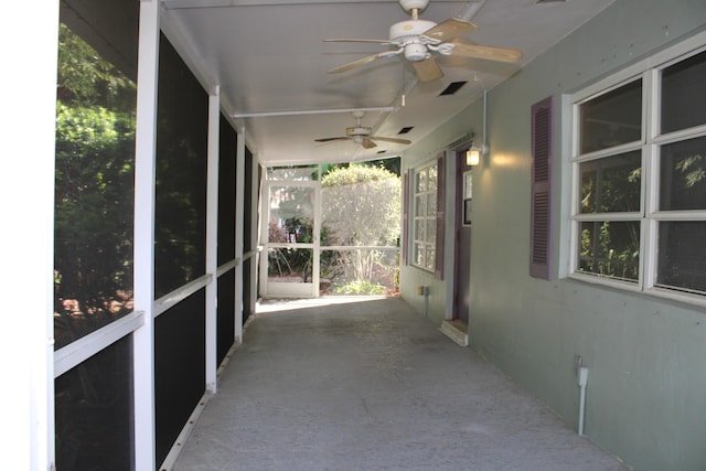 unfurnished sunroom with ceiling fan