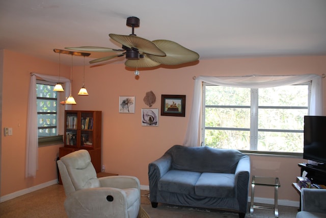 living room featuring ceiling fan and a healthy amount of sunlight