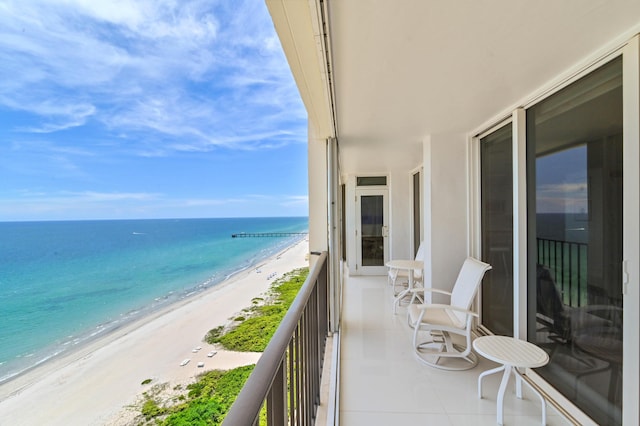 balcony featuring a water view and a view of the beach