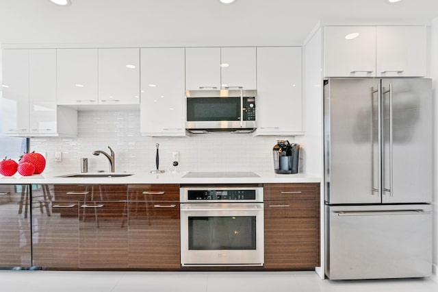 kitchen with white cabinetry, appliances with stainless steel finishes, sink, and tasteful backsplash