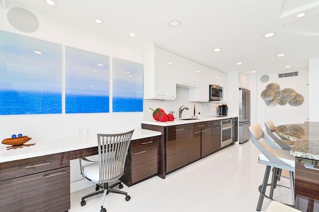 interior space featuring dark brown cabinets, sink, stainless steel appliances, and white cabinets