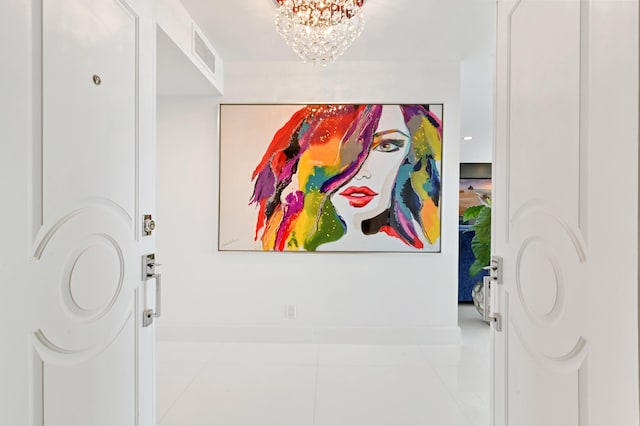 hallway featuring a chandelier and light tile patterned floors