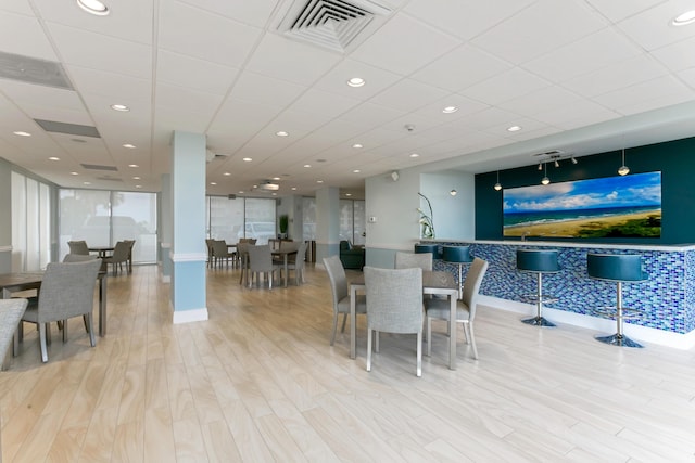 dining area with light wood-type flooring and a drop ceiling