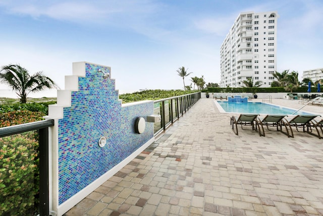 view of pool with a patio and pool water feature