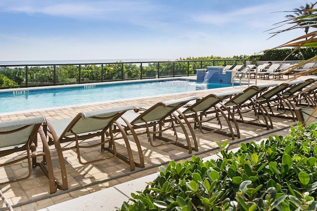 view of swimming pool featuring pool water feature and a patio