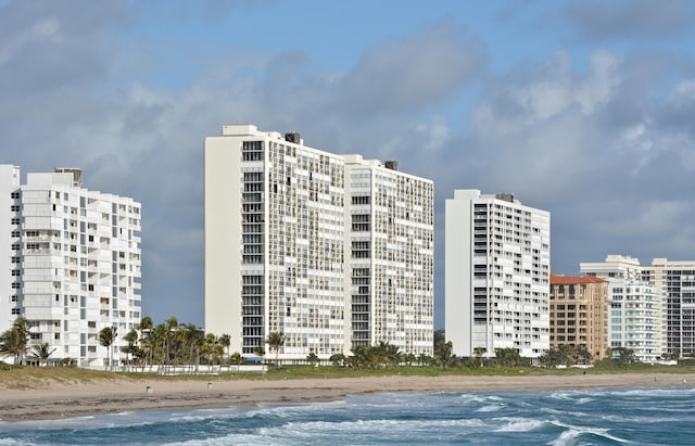 view of building exterior with a beach view and a water view