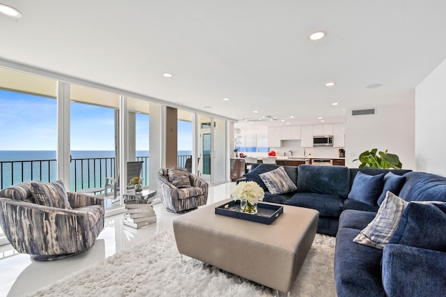 living room with floor to ceiling windows and a water view