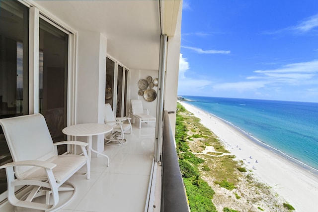 balcony featuring a water view and a view of the beach