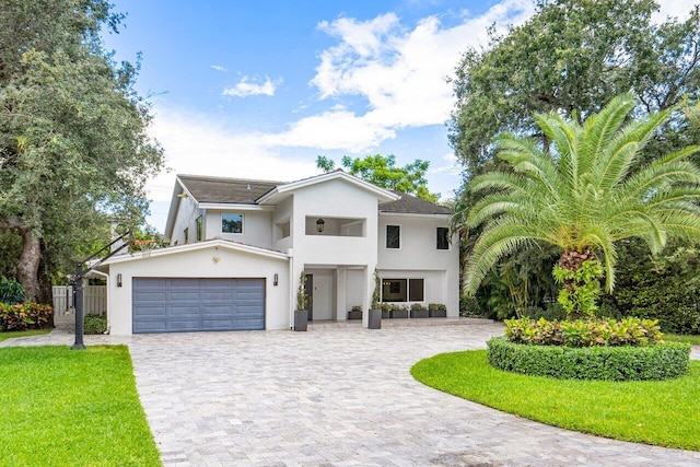 1145 SW 20th St, Boca Raton, FL 33486 - view of front facade featuring a front yard, fence, stucco siding, a garage, and decorative driveway