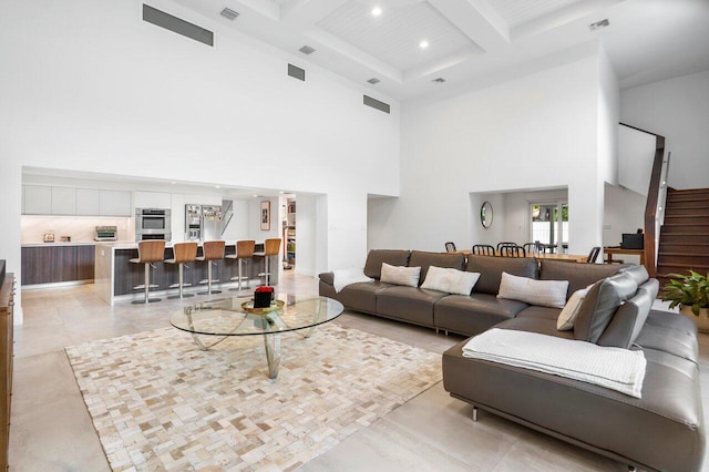 living room with a towering ceiling, coffered ceiling, and beam ceiling