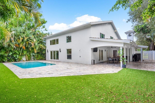 back of house featuring a fenced in pool, a patio area, a lawn, and ceiling fan