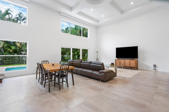 living room with a towering ceiling, coffered ceiling, and beamed ceiling