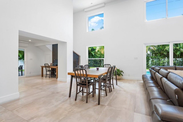 dining room with a towering ceiling and plenty of natural light