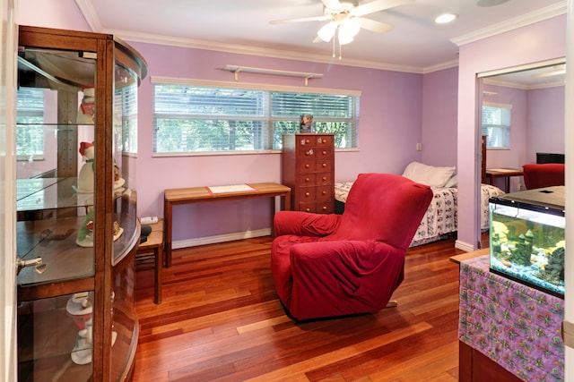 living area with crown molding, hardwood / wood-style floors, and ceiling fan