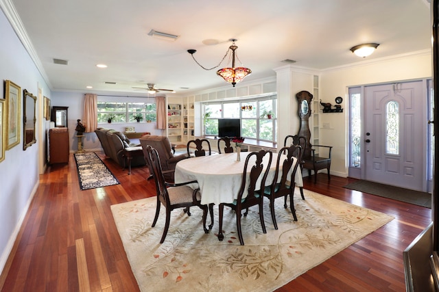 dining space featuring ceiling fan with notable chandelier, dark hardwood / wood-style floors, built in shelves, and ornamental molding