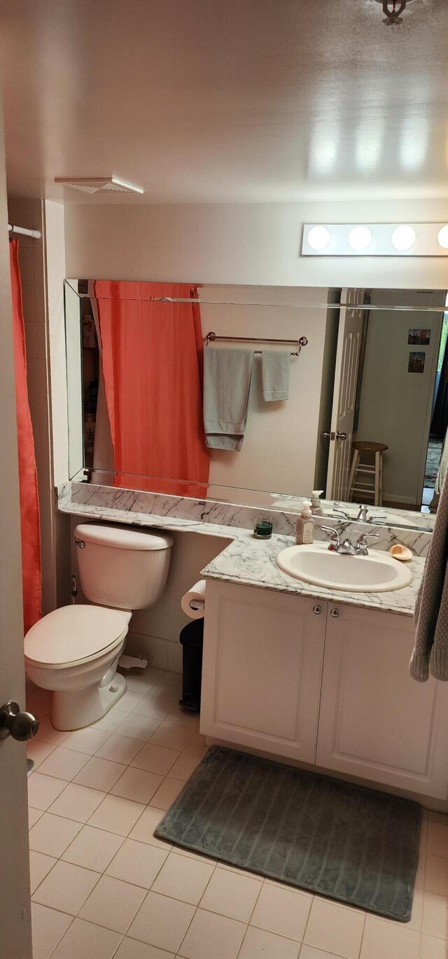 bathroom featuring tile patterned flooring, vanity, and toilet