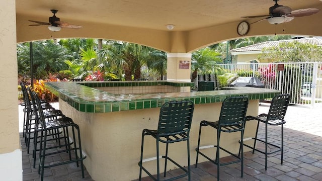 view of patio with exterior bar and ceiling fan