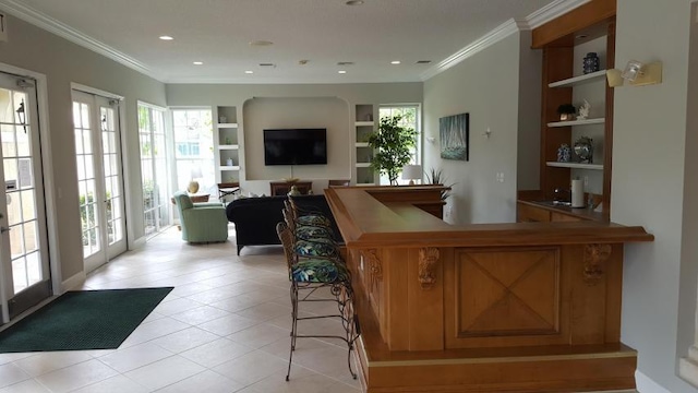 bar with french doors, light tile patterned floors, built in features, and ornamental molding