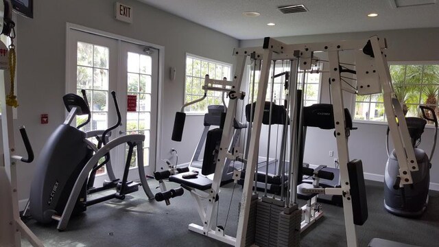 workout area with a healthy amount of sunlight and a textured ceiling