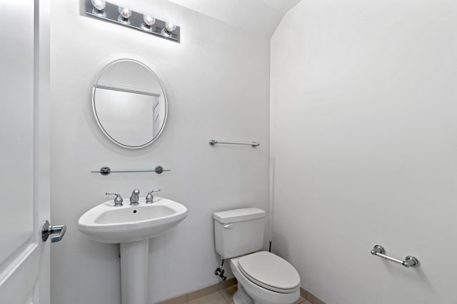 bathroom with toilet and tile patterned flooring