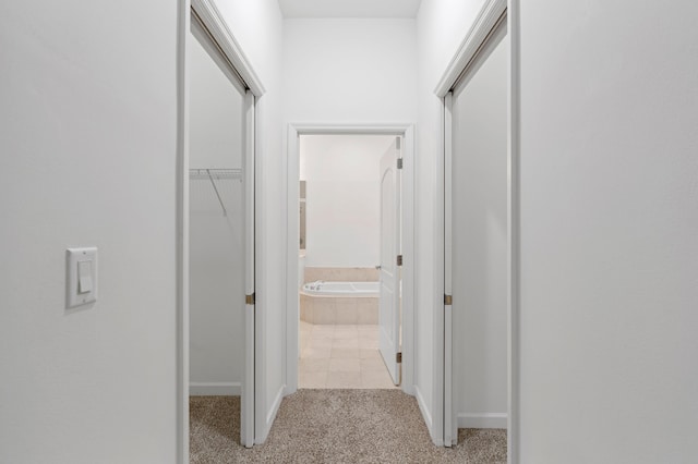 hall featuring light colored carpet