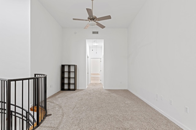 empty room with light colored carpet and ceiling fan