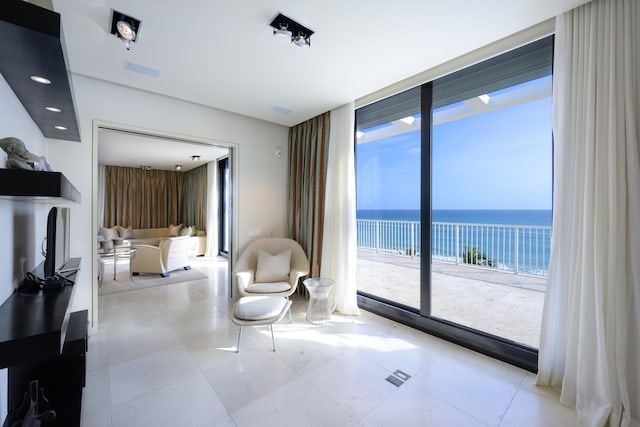 sitting room featuring a water view and tile patterned flooring