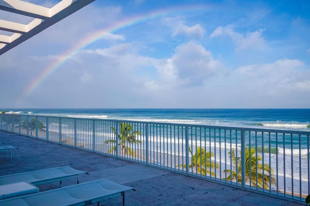 balcony with a water view and a beach view