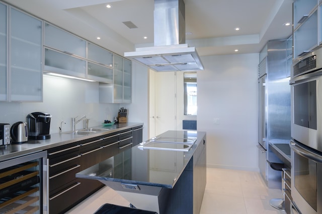 kitchen featuring a kitchen island, electric cooktop, beverage cooler, island exhaust hood, and stainless steel double oven